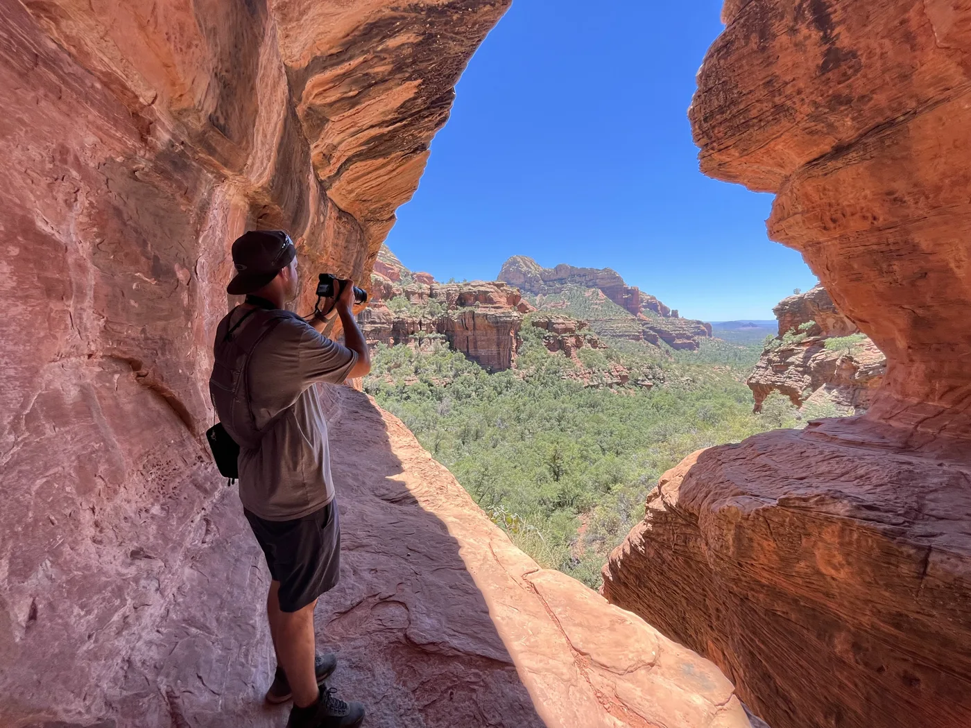 Ryan photographing through a red-rock arch in Sedona, Arizona