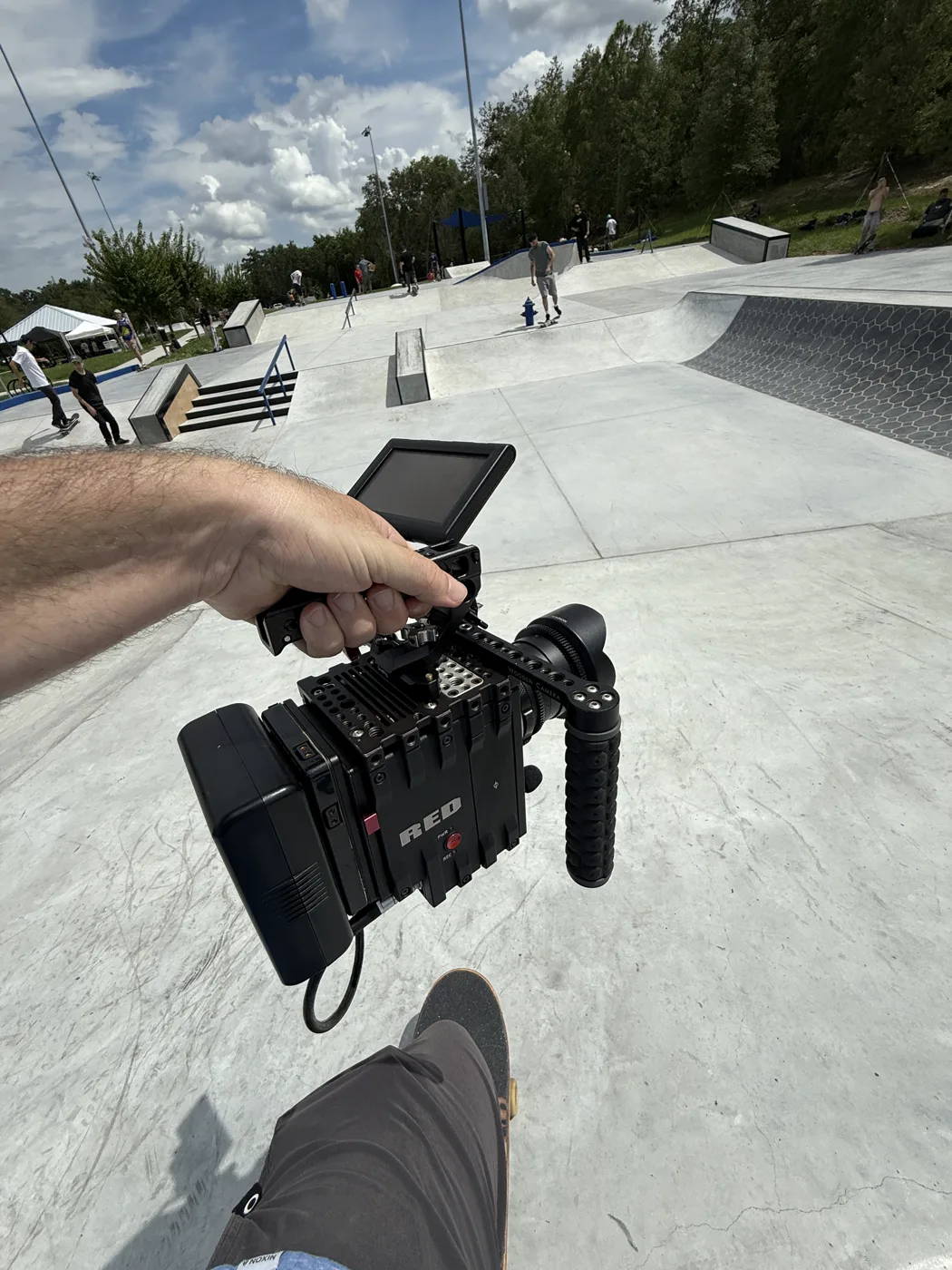 Point-of-view shot holding a RED cinema camera at a skatepark