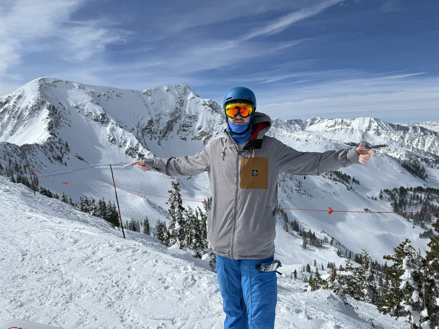 Ryan on a snowy mountain summit with arms outstretched