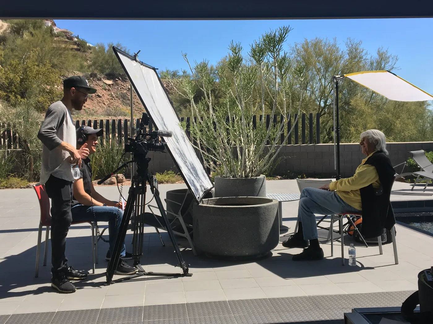 Outdoor interview setup with a camera and reflector on a desert patio