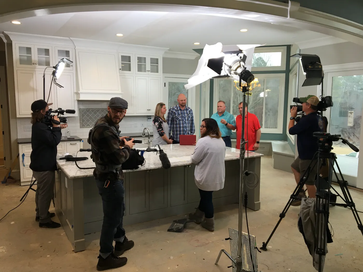 Reality TV crew filming a scene in a newly built kitchen