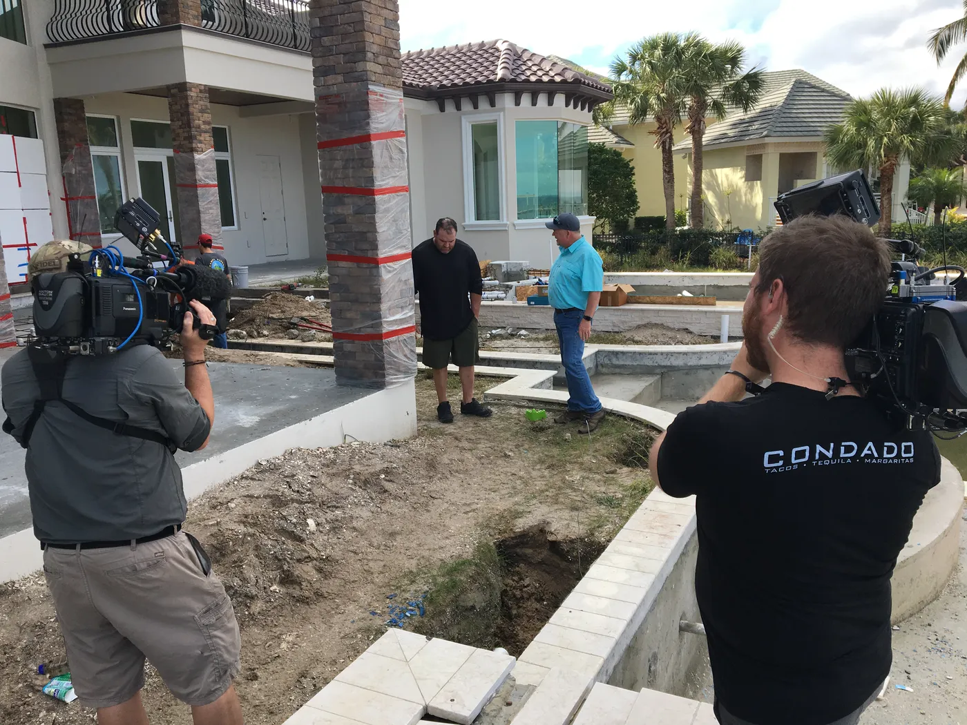 Camera operators filming a backyard pool construction